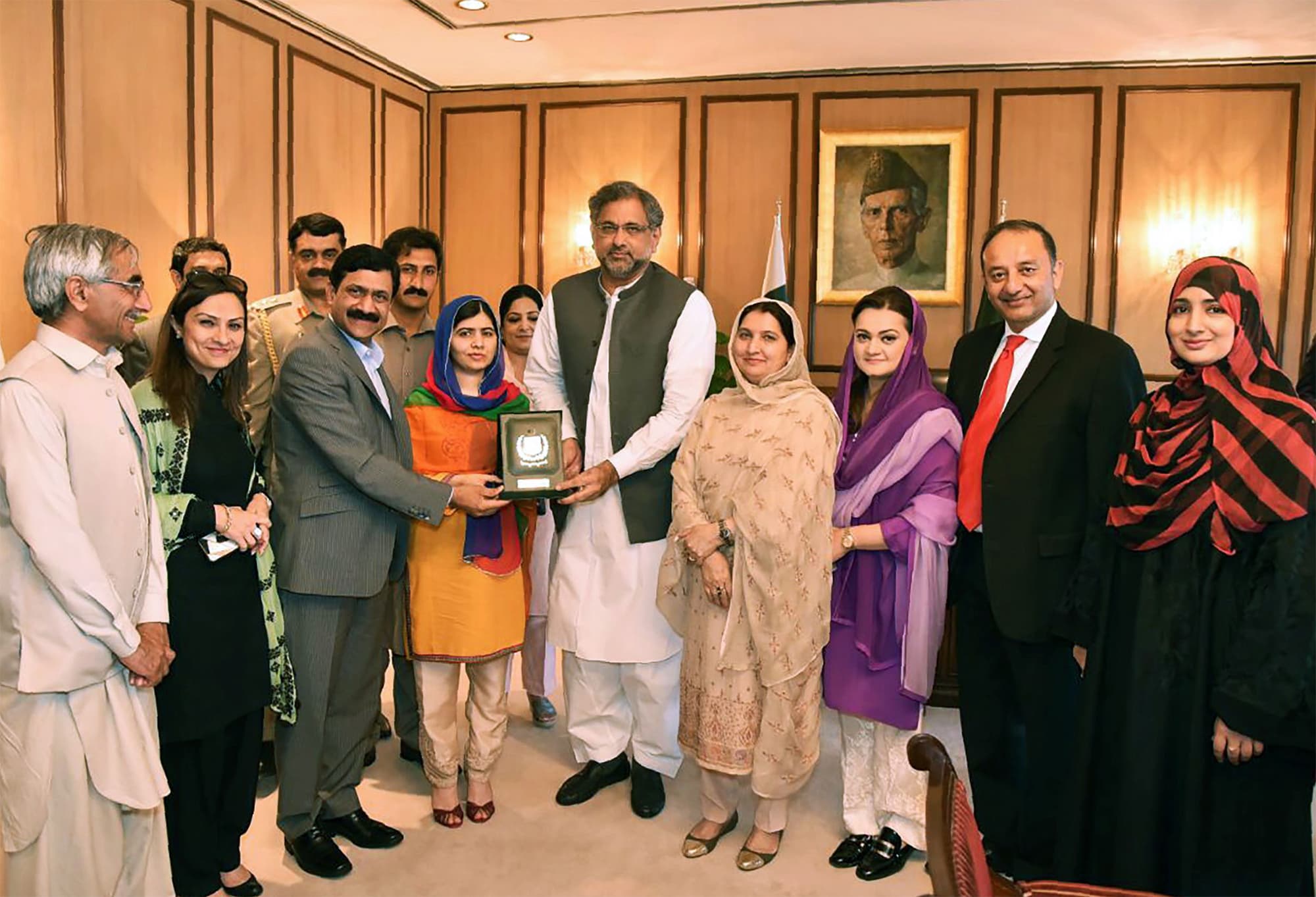 This handout photograph released by the Press Information Department (PID) on March 29, 2018, shows PM Abbasi (C) presenting a shield to Malala at Prime Minister Office during her visit to Islamabad. ─ AFP