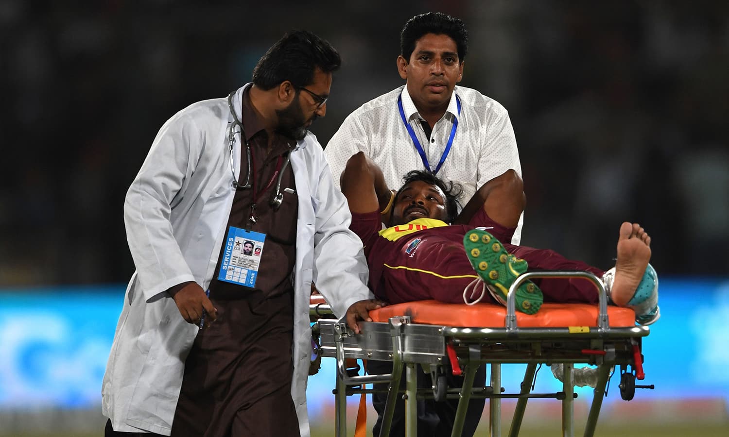 West Indies bowler Veerasammy Permaul gestures as he lies on a stretcher after injury during the first T20 cricket match between Pakistan and West Indies at The National Stadium in Karachi. ─AFP