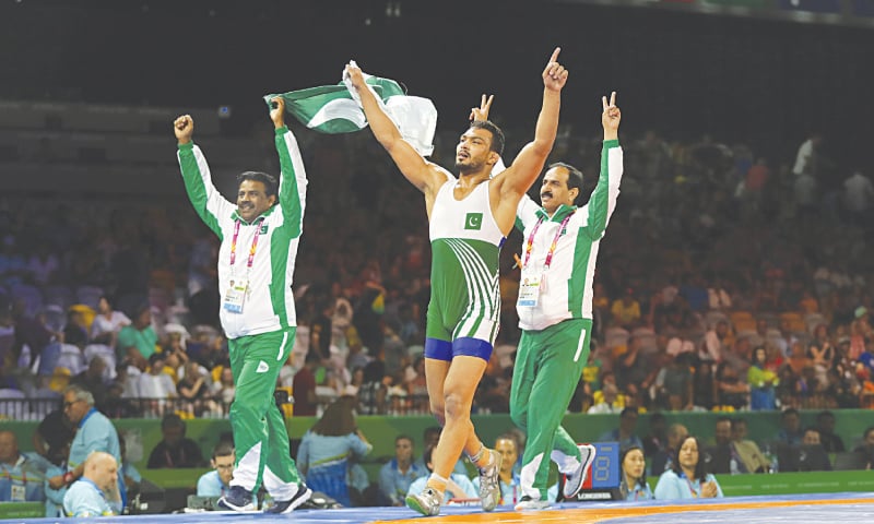 GOLD COAST: Pakistan’s Mohammad Inam Butt (C) takes a victory lap with his coaches after winning in the men’s freestyle 86Kg wrestling finals against Nigeria’s Melvin Bibofinals at the Commonwealth Games on Saturday.—AP