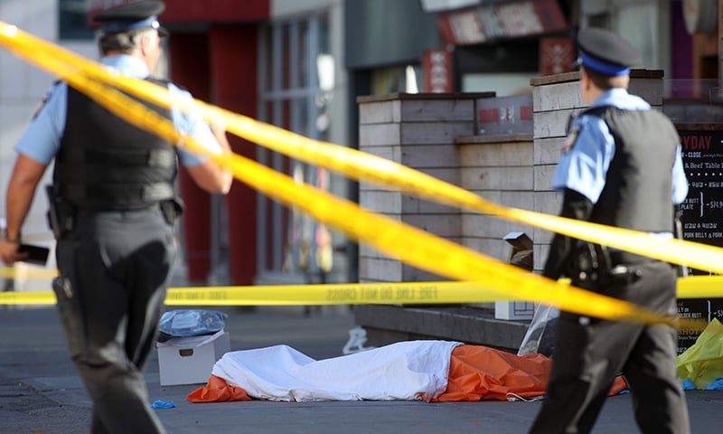 Police officers stand near one of the bodies on the street after a truck drove up on the curb and hit several pedestrians in Toronto. — AFP