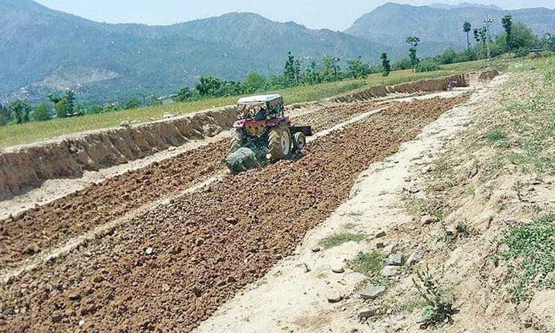 A landowner ploughs the land allocated for the road project. &mdash; Dawn