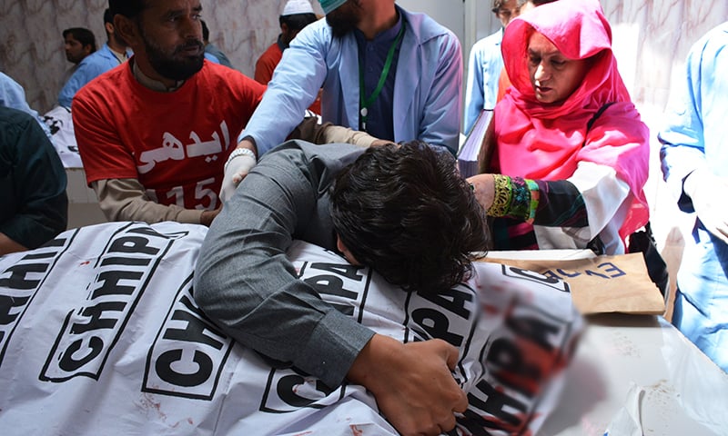 A man mourns the death of a relative at a hospital after assailants opened fire at an electronics shop in Quetta on Saturday. — AFP