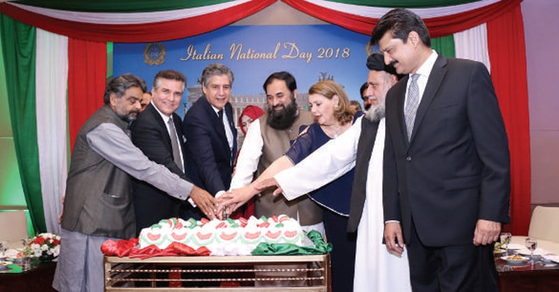 Ambassador Stefano Pontecorvo and chief guest Minister Balighur Rehman lead the cake cutting ceremony at the Italian National Day celebrations in Islamabad.