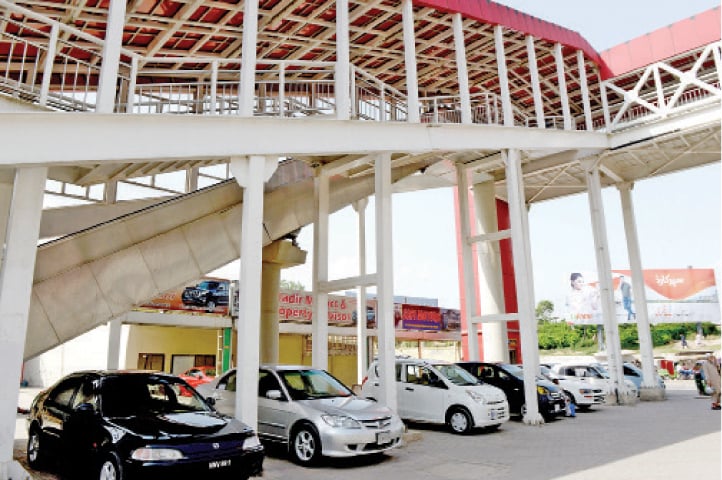 Car dealers have parked vehicles under the metro bus station at Marrir Chowk in Rawalpindi. 
&mdash; White Star