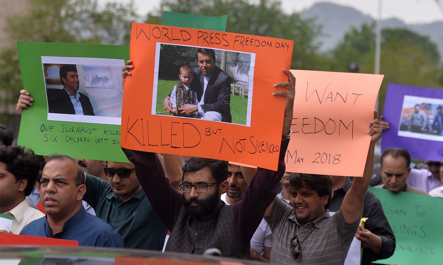 ریلی کے شرکا افغانستان حملے میں ہلاک ہونے والے صحافیوں کی تصاویر پر مشتمل پلے کارڈ اٹھائے ہوئے ہیں
&mdash;فوٹو: اے ایف پی