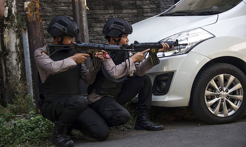 Mobile brigade police take position as they patrol outside the Surabaya police headquarters following a suicide attack in Surabaya on Monday. — AFP Mobile brigade police take position as they patrol outside the Surabaya police headquarters following a suicide attack in Surabaya on Monday. — AFP