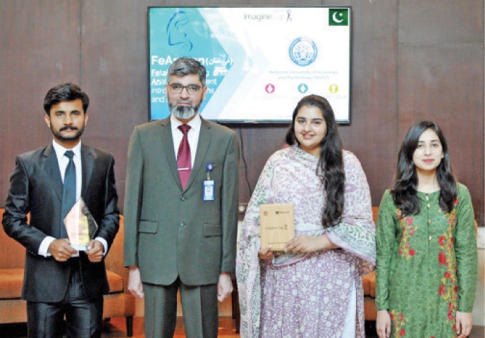 Winners of the competition pose with their teacher. — Dawn