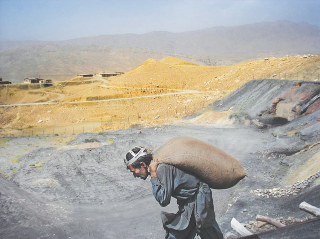 A miner hauls a sack of coal on his back; despite the toil and labour, miners opt for mining as a life-long profession | Photo by Mukhtar Azad