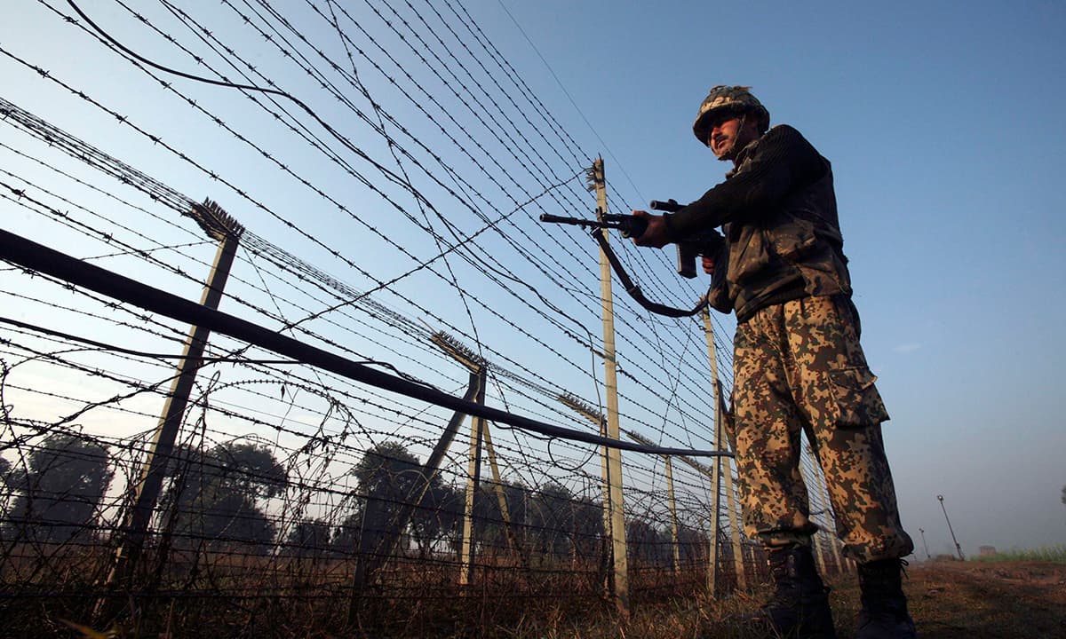 An Indian sholdier patrols the fenced border with Pakistan near Suchetgarh | Reuters