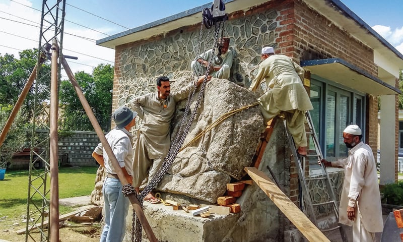 Rock carving of Bodhisattva Padmanpani being fixed on the premises of Swat Museum. &mdash; Dawn