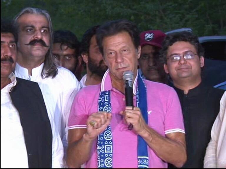 PTI chairman Imran Khan talks to party workers.