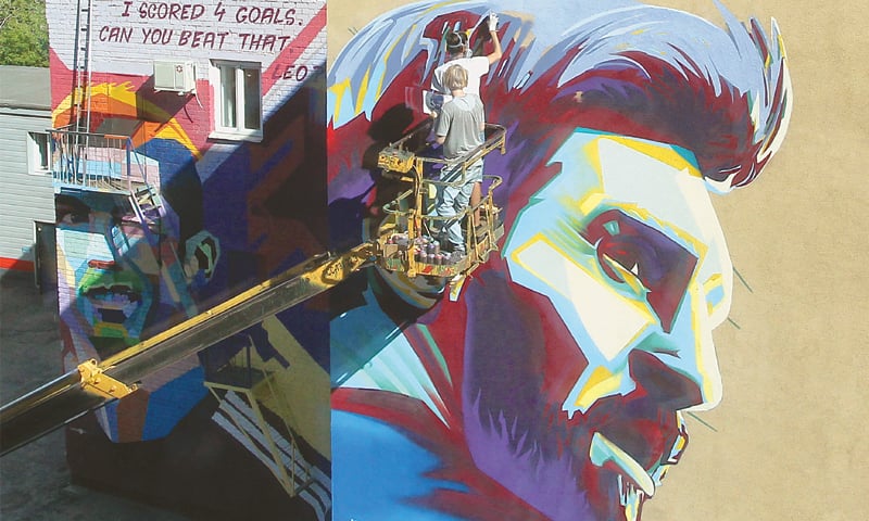 KAZAN: Russian graffiti artists make a mural of Lionel Messi next  to the mural of Cristiano Ronaldo.&mdash;Reuters