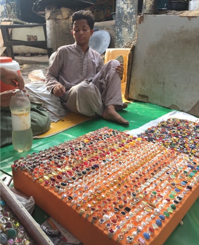 A young boy selling rings outside the Shah Noorani shrine