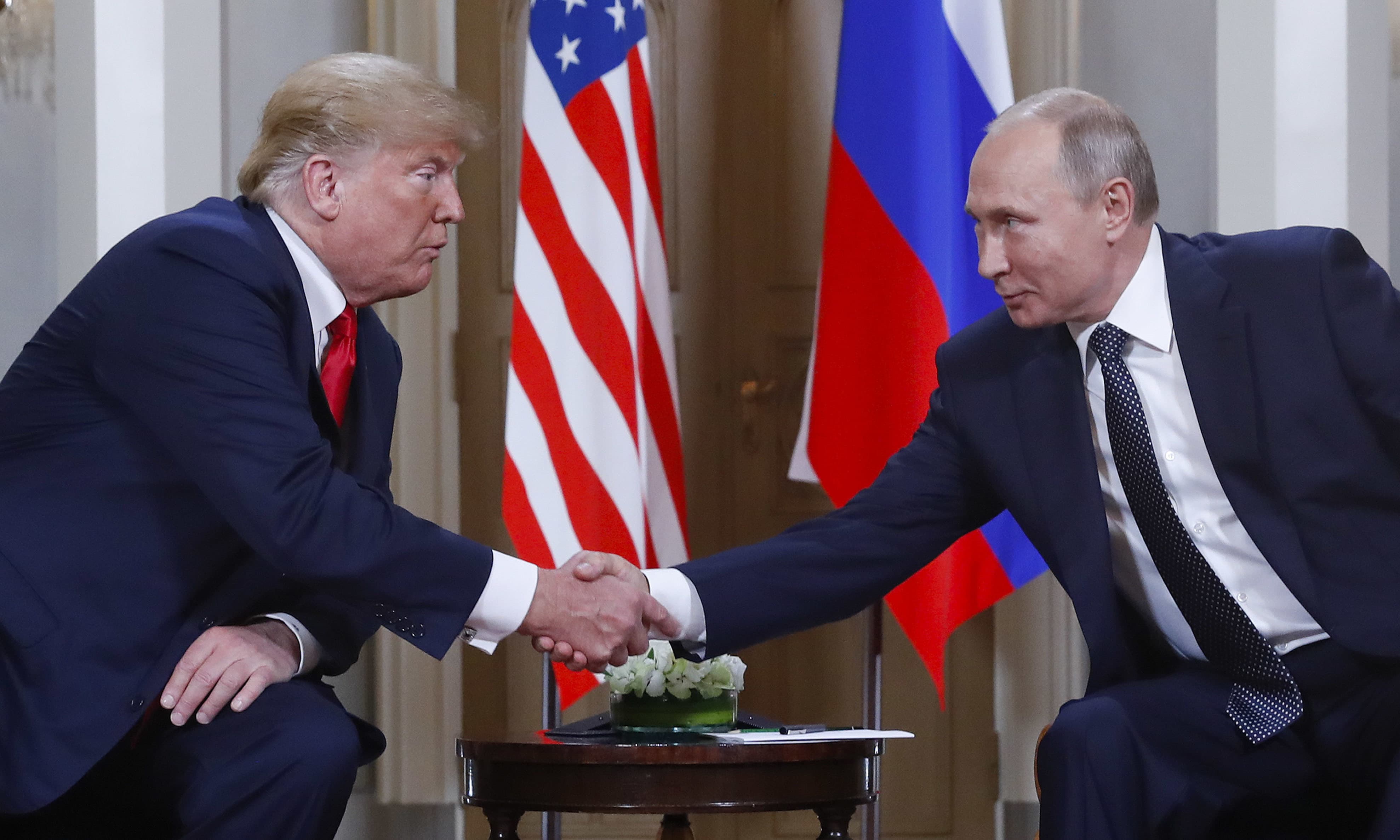 US President Donald Trump and Russian President Vladimir Putin shake hands during their meeting in the Presidential Palace in Helsinki on Monday. — AP