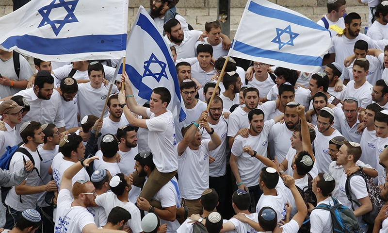 In this May 13, 2018, file photo, Israeli youths wave national flags outside the Old City's Damascus Gate, in Jerusalem. &mdash;AP
