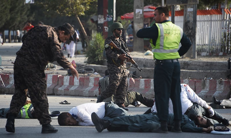 Afghan security forces stand near bodies of victims following a suicide attack in Kabul on July 22, 2018. —AFP