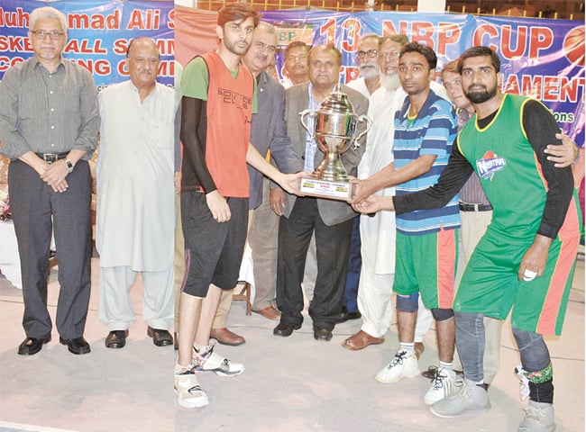 KARACHI: NBP’s sports head and former Test spinner Iqbal Qasim hands winners trophy to Bounce Club captain Muzammil Hussain at Arambagh court on Monday.