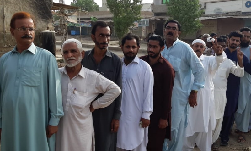 People line up outside a polling station in Sanghar. — DawnNewsTV