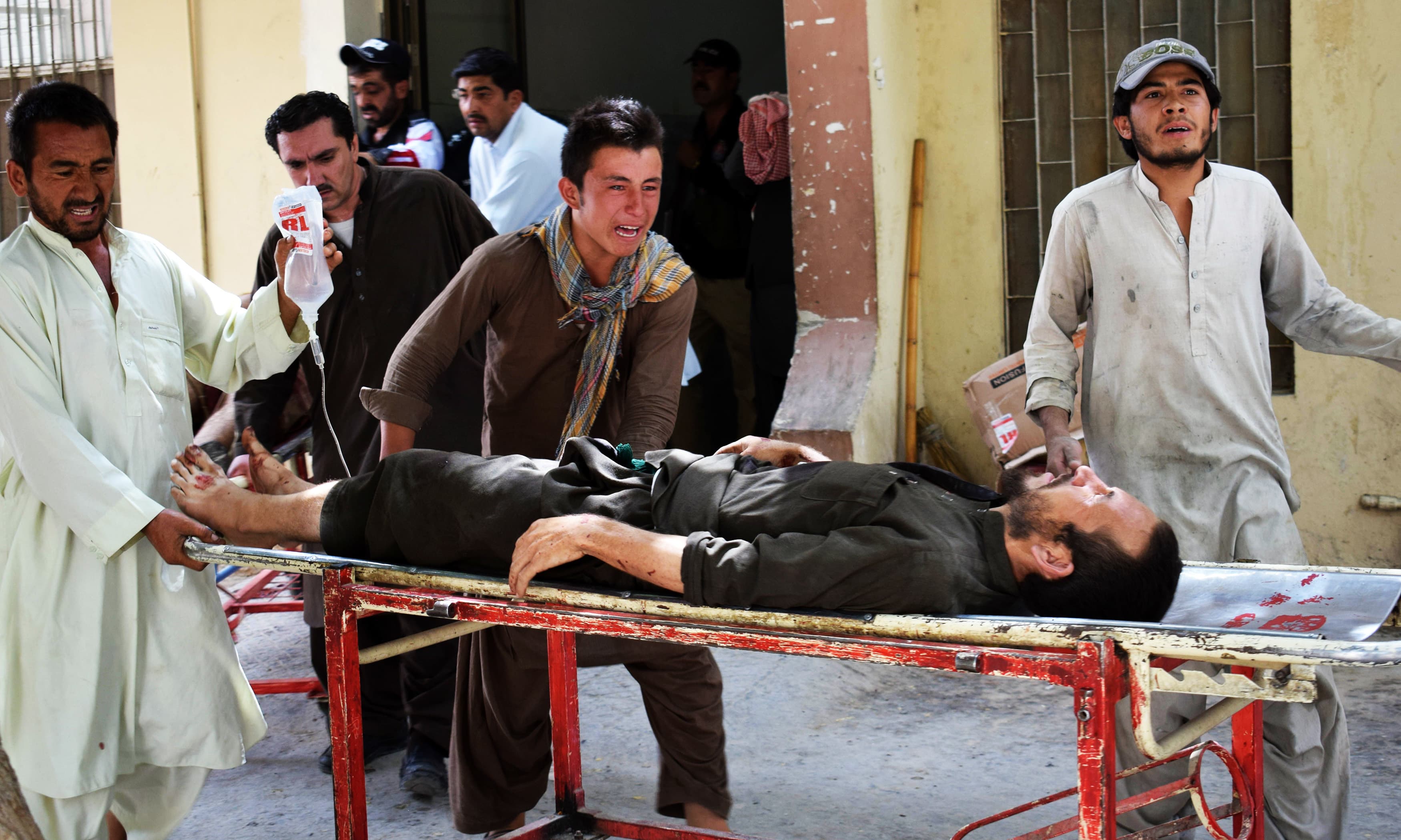 Relatives reacts as they carry an injured blast victim. —AFP