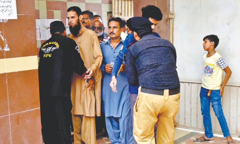 LAW enforcers frisk voters outside a polling station in Azizabad while (right) an elderly voter is helped to complete the formalities before casting his ballot in a Gulshan-i-Iqbal polling facility on Wednesday.—Fahim Siddiqi / White Star