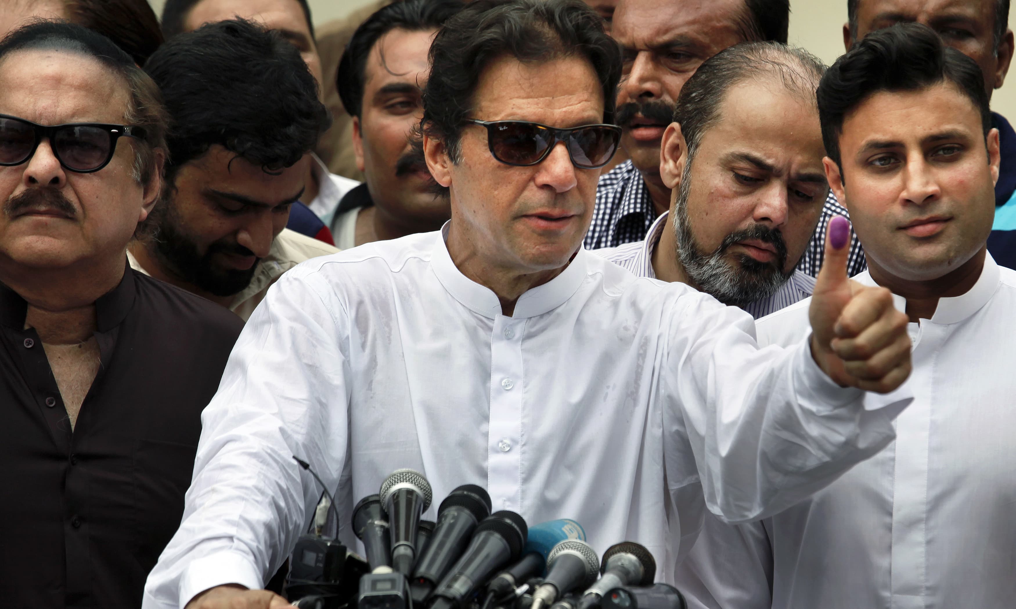 Imran Khan shows his marked thumb after casting vote. &mdash;AP/File