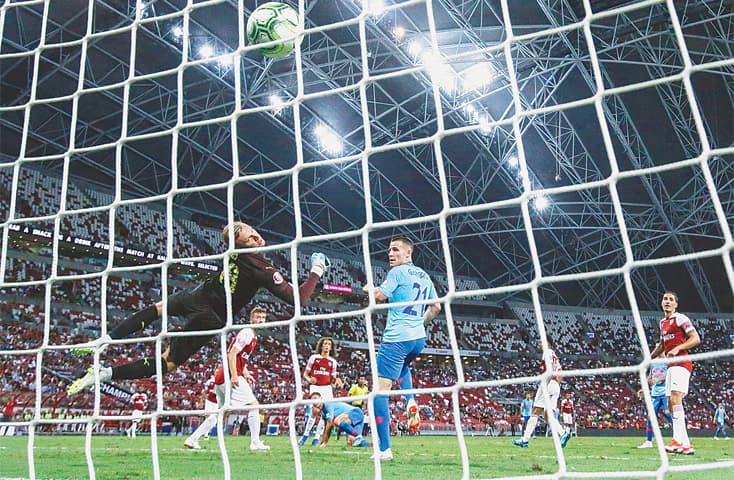 SINGAPORE: Atletico Madrid’s Luciano Vietto (C) scores against Arsenal during their International Champions Cup match on Thursday.—AP