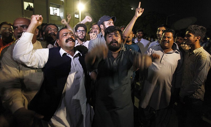 Supporters of ex-PM Nawaz Sharif chant slogans outside the cardiac ward of Pims on Sunday. — AP