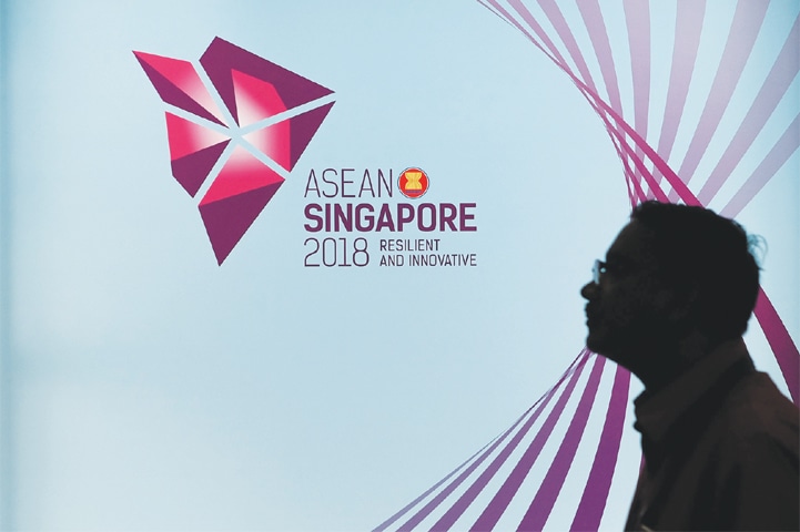 A MAN looks at a banner in Singapore on Wednesday ahead of the Association of Southeast Asian Nations (Asean) Regional Forum. The annual forum brings together the top diplomats from 26 countries and the European Union for talks on political and security issues in Asia-Pacific.—AFP