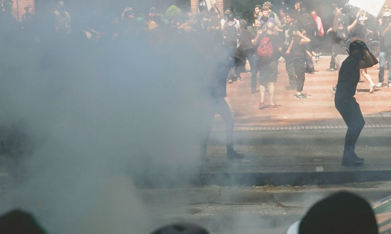 Portland: Police push protesters back with tear gas and flash-bang grenades during 
a rally.—AP