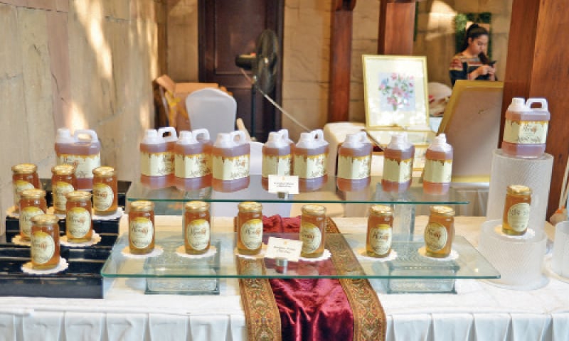 Visitors look at ornaments at a stall in the bazaar on Friday. The other pictures show footwear and honey on display. &mdash; Photos by the writer
