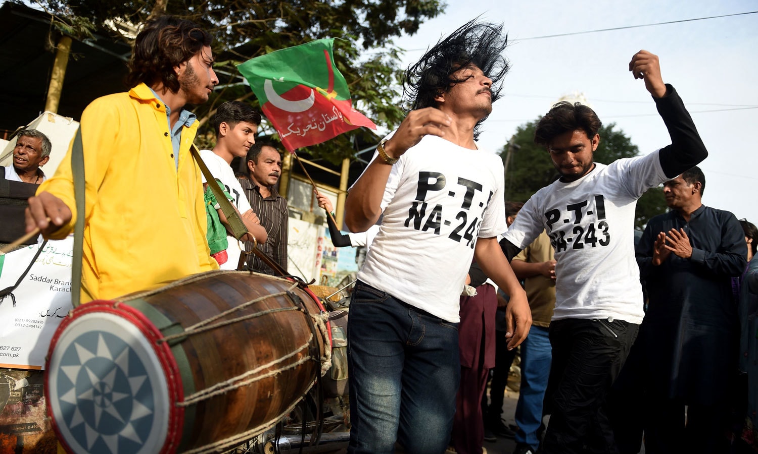 عمران خان کے وزیر اعظم کا عہدہ سنبھالنے پر پی ٹی آئی کارکنان نے ڈھول کی تھاپ پر رقص کیا اور مٹھائیاں تقسیم کیں &mdash; فوٹو: اے ایف پی