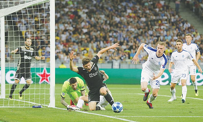 KIEV: Ajax Amsterdam’s Klaas Jan Huntelaar (C) and Dynamo Kiev’s Mykyta Burda (R) vie for the ball during the UEFA Champions League play-off second leg at the Olympiyskiy Stadium.—AP