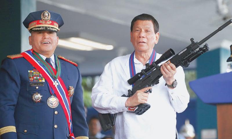 In this April 19 file photo, Philippine President Rodrigo Duterte holds an Israeli-made Galil rifle presented to him by a former police chief, Ronald  Dela Rosa, at a ceremony in Quezon city.—AP