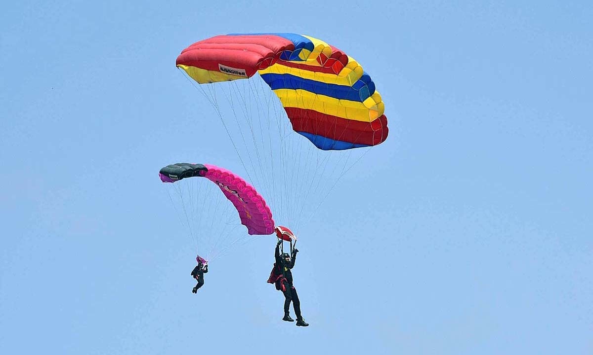 Para-troopers demonstrate their skills during a programme to mark Defence Day at Karnal Sher Khan (Shaheed) Stadium in Peshawar. — APP