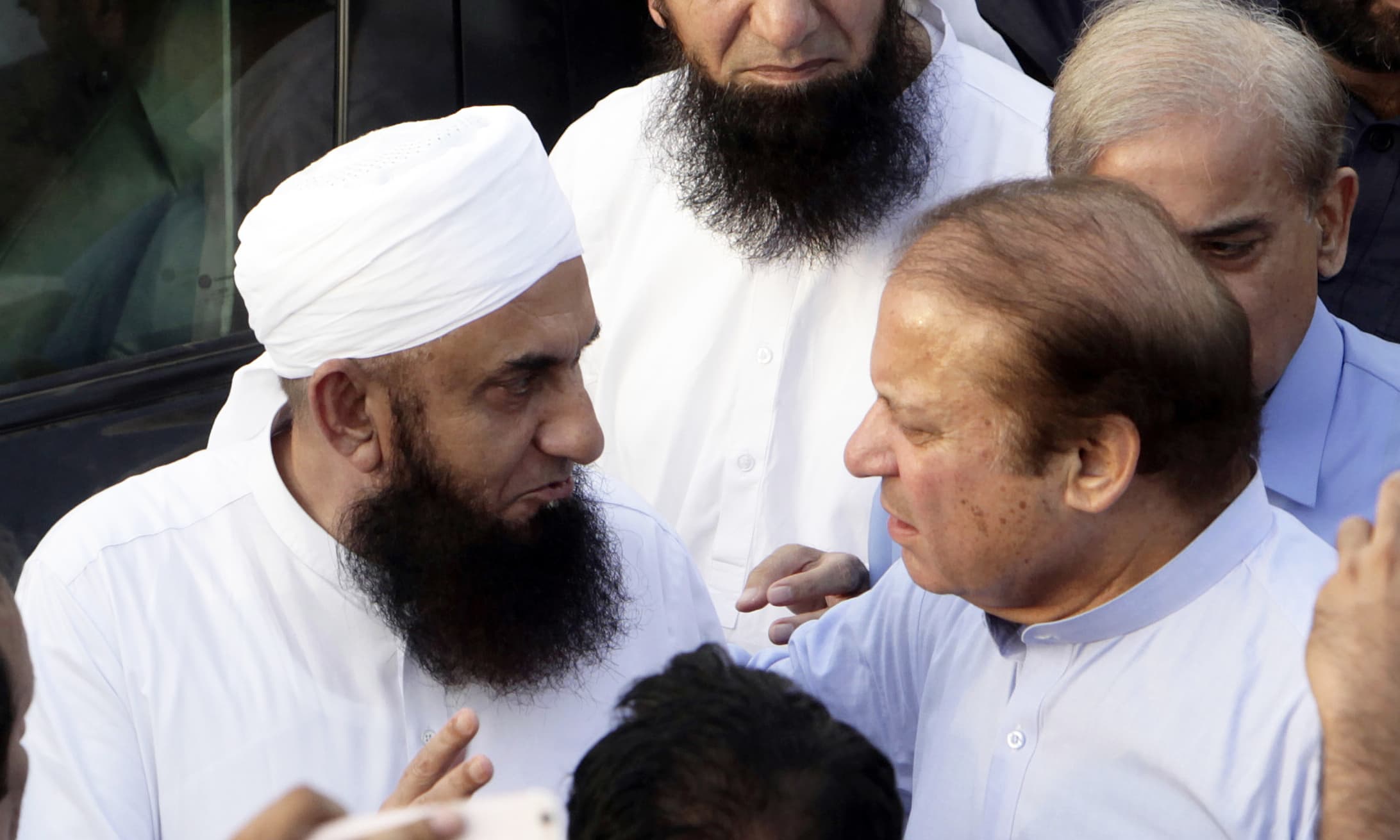 Nawaz Sharif talks with Maulana Tariq Jameel as he arrives to attend the funeral. —AP