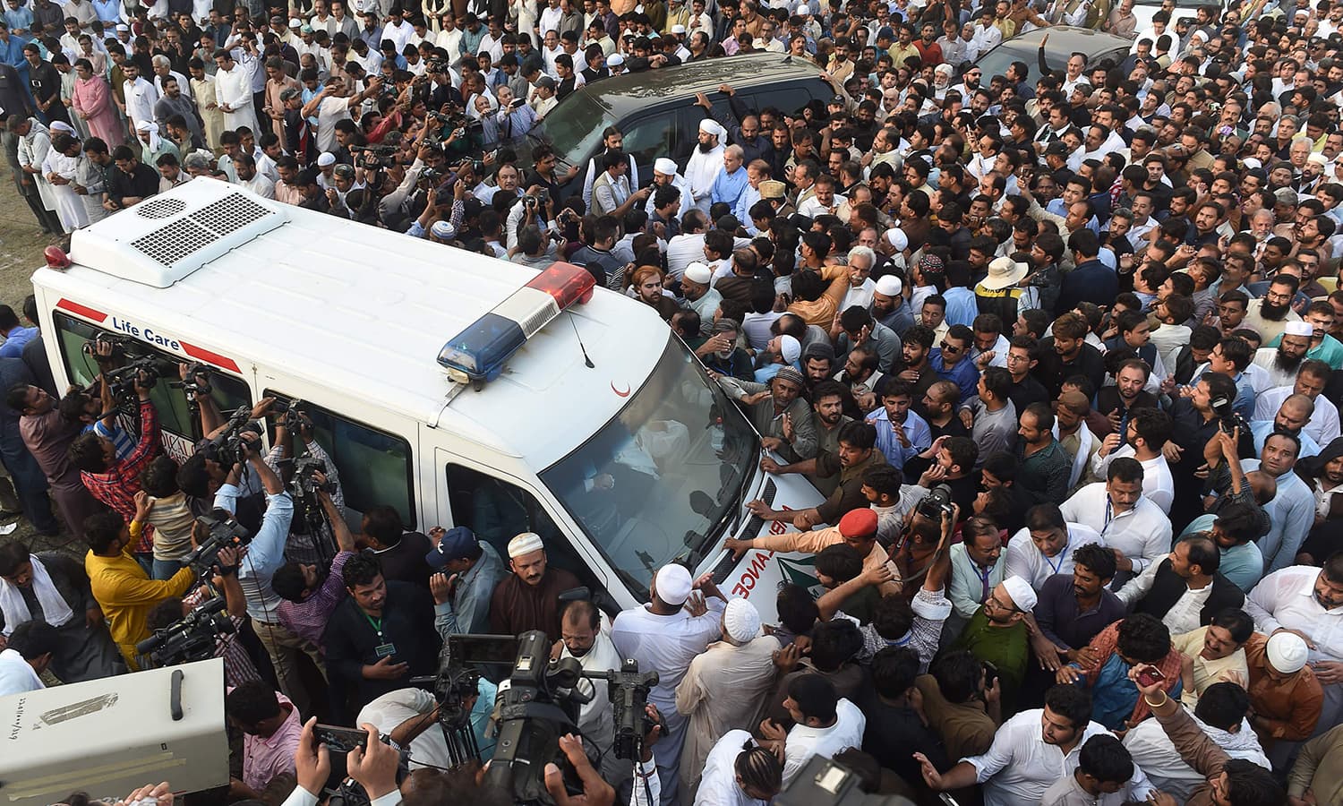 ہزاروں افرا کلثوم نواز کی نماز جنازہ کے بعد ایمبولنس کے قریب موجود ہیں —فوٹو :  اے ایف پی