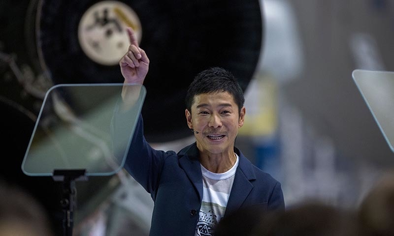 Yusaku Maezawa reacts near a Falcon 9 rocket during the announcement by Elon Musk to be the first private passenger who will fly around the Moon &mdash; AFP