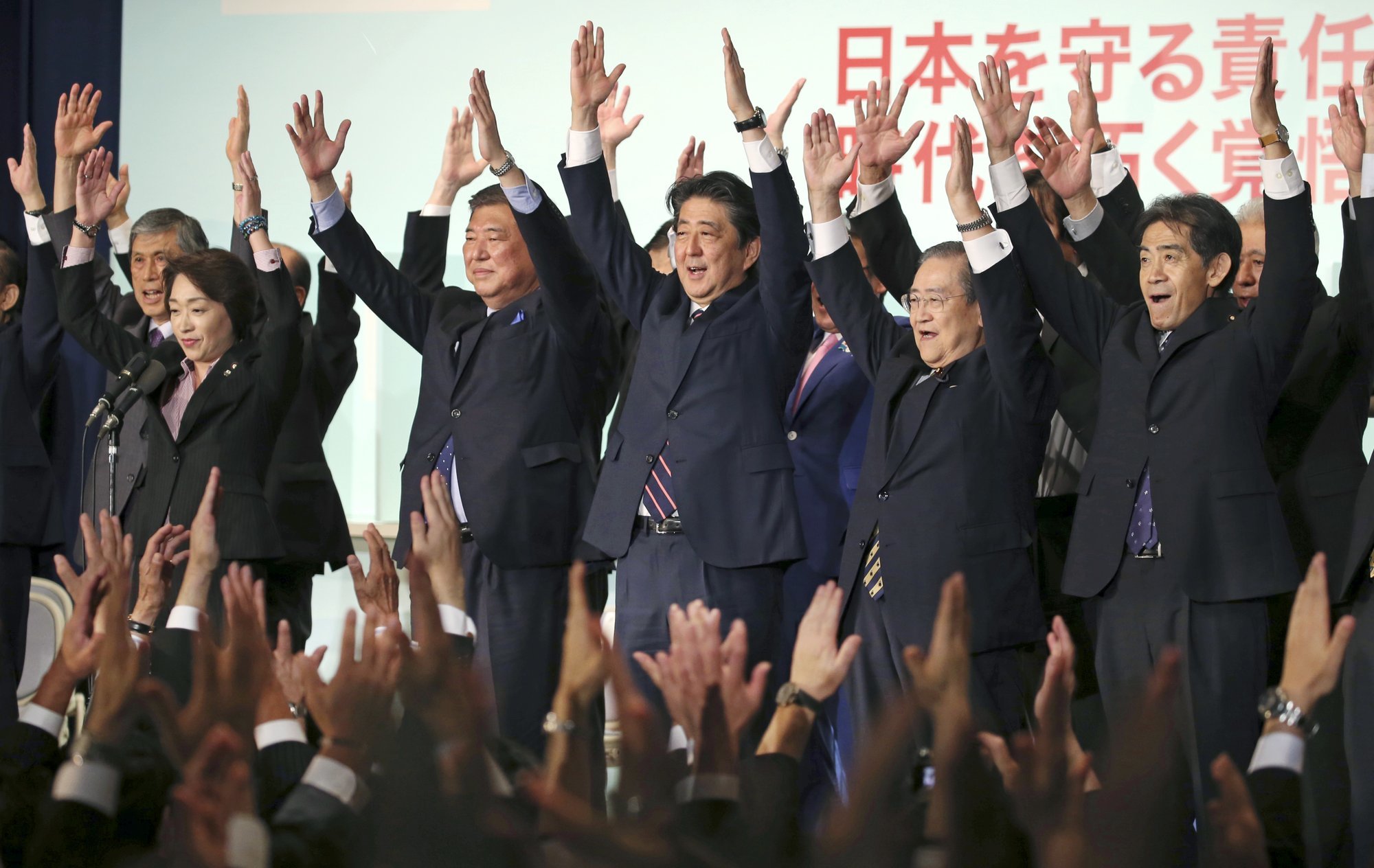 Japan's Prime Minister Shinzo Abe, center, shouts traditional "Banzai (long life)" cheers with other Liberal Democratic Party lawmakers shortly after winning of the ruling party presidential elections at its headquarters in Tokyo on Thursday. &mdash; AP