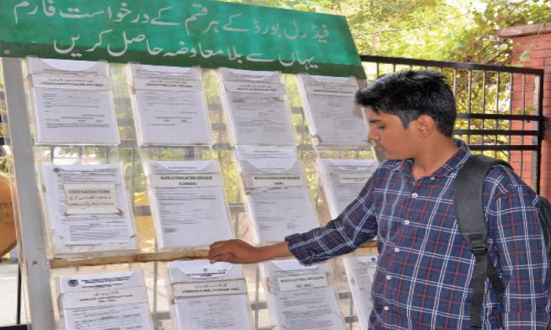 A visitor to the board office takes a form from the display section. Various forms and documents are available at one location for students&rsquo; convenience.