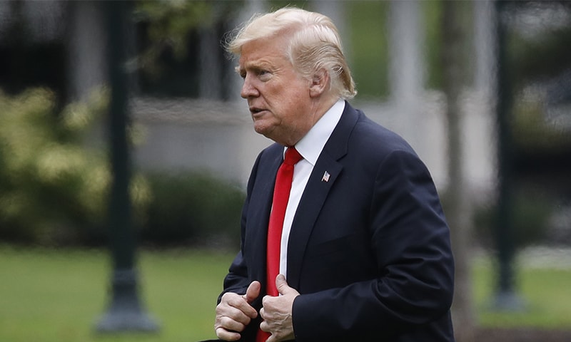US President Donald Trump walks across the South Lawn on return from New York City. ─ AP