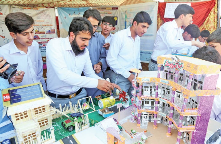 A student briefs visitors about his power generator model at the exhibition. &mdash; Dawn