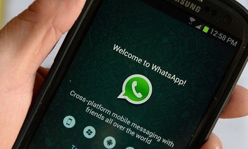 A user looks at WhatsApp on a smartphone. &mdash; File
