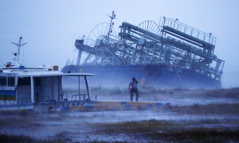 A vessel's rear tilts on one side as it ran ashore at a pier with a typhoon approaching Yonabaru, Okinawa prefecture. &mdash;AP