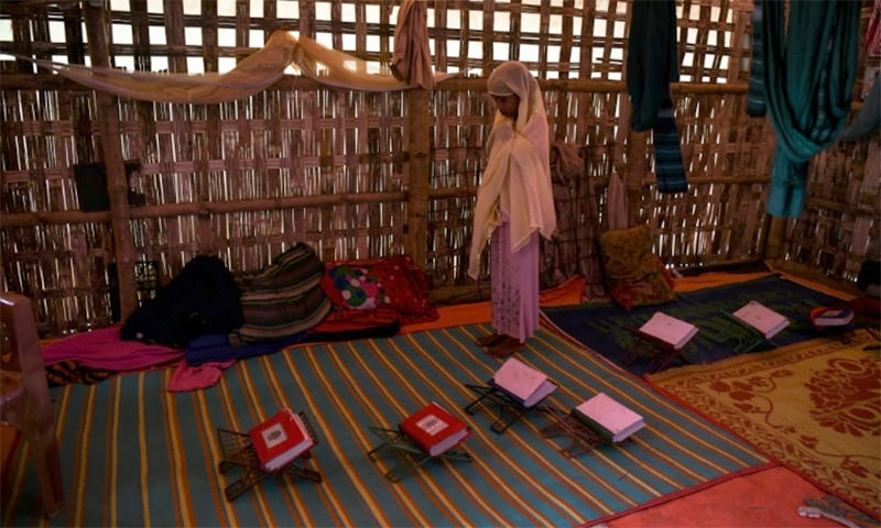 As the boys in her class file out to perform their ablutions, Saleema, the lone girl, stays behind to pray. ─ AFP