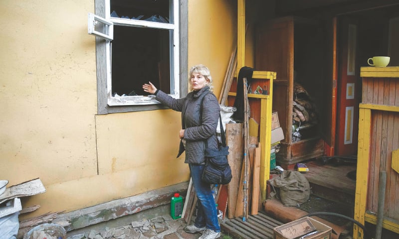 (Top): Smoke rises after a fire and explosions hit the ammunition depot. (Below left) A resident shows a broken window of her house. (Right) A damaged elevator in the town of Ichnya.&mdash;Reuters