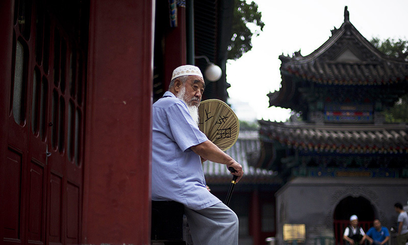A Chinese Muslim man fans himself as he waits for the time to break his fast. &mdash; File Photo/AP