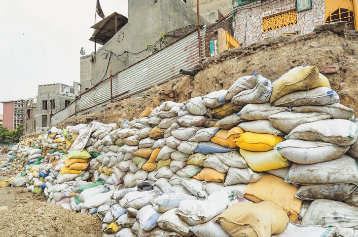 Polypropylene sand bags have been stacked to support damaged property