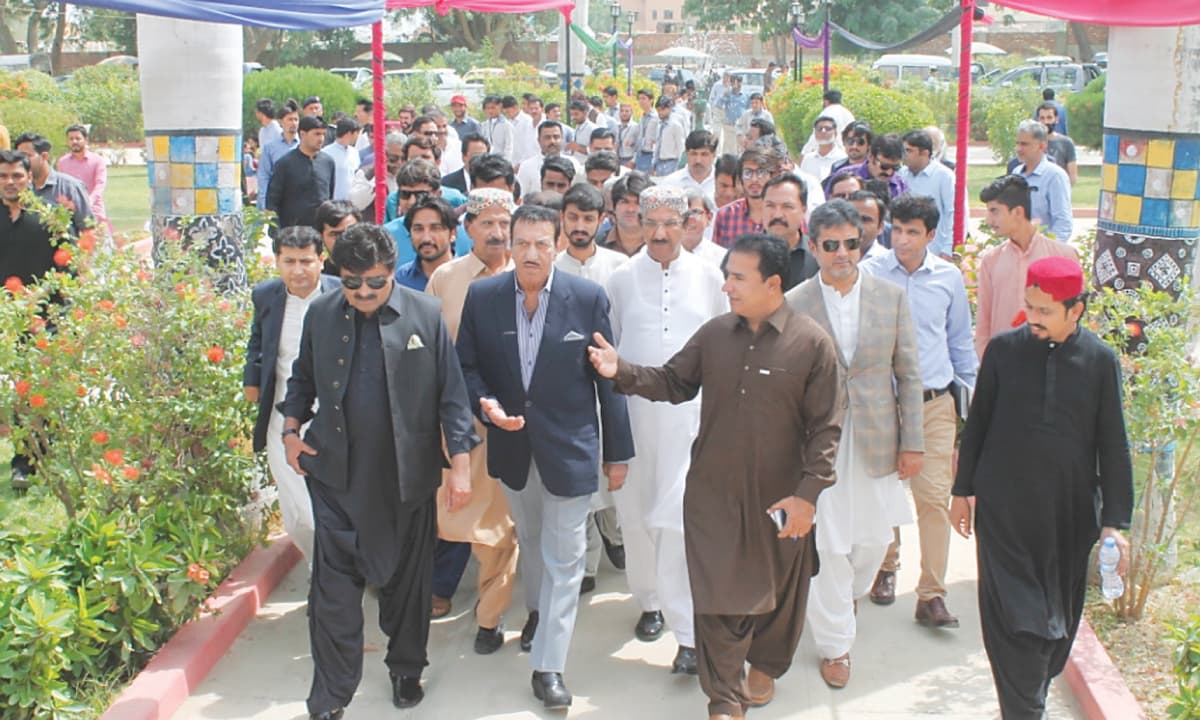 Film icon Mustafa Qureshi, along with minister for culture, VC of Sindh University and others, walk towards auditorium before the seminar at the Institute of Sindhology.&mdash;Dawn