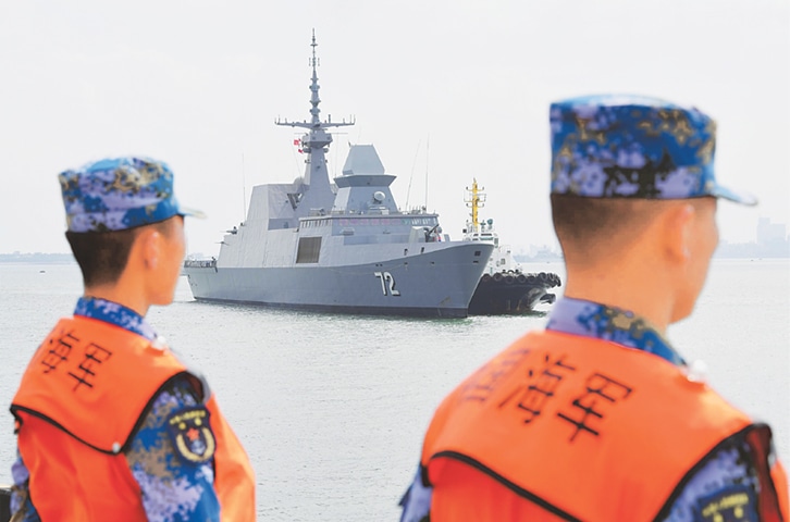 Zhanjiang (Guangdong province, China): Sailors watch as a Singapore navy ship arrives at a port in China.—AFP