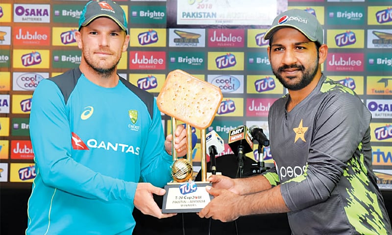 Australian captain Aaron Finch (L) and Pakistan skipper Sarfraz Ahmed pose with the series trophy on the eve of the first Twenty20 International at the Sheikh Zayed Stadium on Tuesday.&mdash; Courtesy PCB